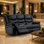 A premium black leather 3-seater power reclining sofa showcased in a modern, elegant hotel lobby with polished marble floors, warm lighting, and a marble-topped coffee table in the foreground.