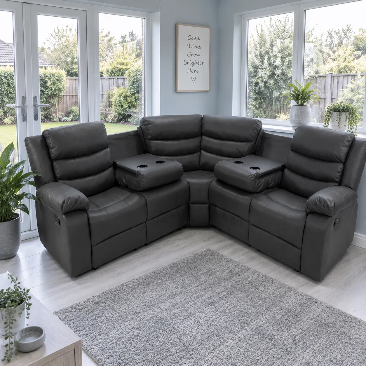 Black corner leather recliner sofa in a spacious entrance hallway with light blue walls, white trim, wooden flooring, a console table, and large mirror, illuminated by natural daylight.