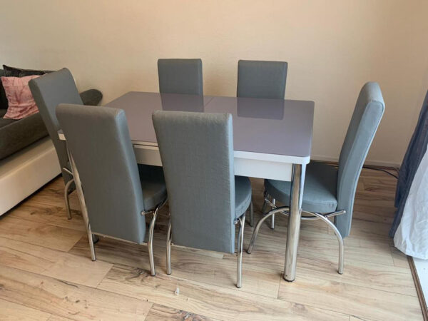 grey dining table and chairs infront of cream color wall