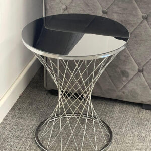 Spider legs table black colour placed infront of sofaside